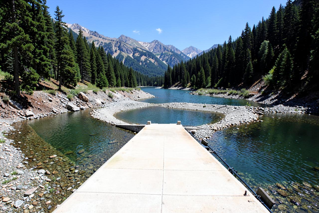 A concrete boat ramp running into low water on a forested Sierra reservoir